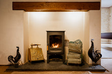 Load image into Gallery viewer, A wood burning stove with a net of logs.
